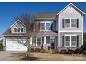 Charming two-story home with gray siding, stone accents, manicured landscaping, and inviting front porch at 1022 Doughton Ln, Indian Trail, NC 28079