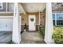 Inviting front porch featuring stone accents, a white front door adorned with a wreath, and lush landscaping at 10321 Solar Way, Charlotte, NC 28278