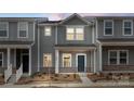 Stylish new construction townhome showcases contemporary design with gray siding, brick accents, and a welcoming front porch at 104 Ciara Pl # B, Mooresville, NC 28117