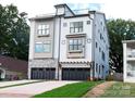 The home showcases a modern design with stone accents, a rooftop terrace, and a two-car garage at 1119 N Myers St, Charlotte, NC 28206