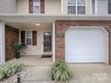 Charming townhome with brick accents, a cozy porch, and an attached one-car garage at 11911 Maria Ester Ct, Charlotte, NC 28277