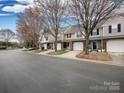 A row of townhomes with mature trees lining the street and well-maintained landscaping at 11911 Maria Ester Ct, Charlotte, NC 28277