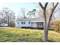 A cozy one-story home with a covered front porch, offering a welcoming curb appeal and ample natural light at 1404 Lane Rd, Mount Holly, NC 28120
