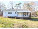 Inviting one-story home with a covered porch, seating, and neat landscaping in a serene setting at 1404 Lane Rd, Mount Holly, NC 28120