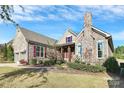 Attractive home with stone accents, red shutters, chimney, and beautifully landscaped front yard at 14920 High Bluff Ct, Charlotte, NC 28278