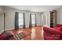 Comfortable living room with hardwood floors, large windows, and cozy seating area at 16417 Grapperhall Dr, Huntersville, NC 28078