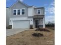 Charming two-story home boasts a two-car garage, neat landscaping, and neutral siding at 202 Brentwood Dr, Statesville, NC 28625