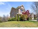 Beautiful landscaped yard of a two-story brick home featuring mature trees and lush greenery at 2251 Barrowcliffe Nw Dr, Concord, NC 28027