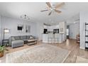 Open concept living room featuring a ceiling fan, sofa, and view of the kitchen with a breakfast bar at 2259 Crosscut Dr, Charlotte, NC 28214