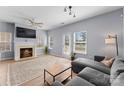Bright living room features a fireplace, ceiling fan, wood floors, and natural light from multiple windows at 2259 Crosscut Dr, Charlotte, NC 28214