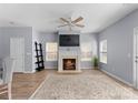 Cozy living room with a fireplace, ceiling fan, and natural light coming through the windows at 2259 Crosscut Dr, Charlotte, NC 28214
