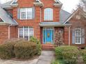 Inviting blue front door with decorative glass and sidelights, framed by lush landscaping at 3516 Araglin Dr, Gastonia, NC 28056