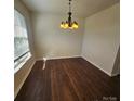 A light-filled dining room featuring hardwood floors and a modern chandelier at 4210 Runaway Cir, Monroe, NC 28110