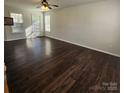 Bright living room showcasing gleaming hardwood floors and natural light through the window at 4210 Runaway Cir, Monroe, NC 28110