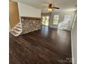 Open-concept living area features a stone fireplace, hardwood flooring, and large windows at 4210 Runaway Cir, Monroe, NC 28110