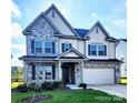 Charming two-story home with stone accents, a well-manicured lawn, and a welcoming front porch at 4253 Stream Dale Nw Cir, Concord, NC 28027