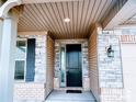 Covered front porch with stone details and a stylish black front door at 4253 Stream Dale Nw Cir, Concord, NC 28027