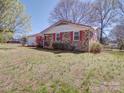 A lovely brick home featuring a red roof and shutters, set on a well-maintained lawn at 4401 Coachwood Ln, Gastonia, NC 28056