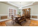 A spacious dining room features a large window, tray ceiling, and a wood table with bench seating at 4858 Sagittarius Cir, Denver, NC 28037