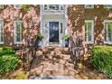 Inviting front entryway with brick steps, black door, and decorative planters exudes classic elegance at 5114 Morrowick Rd, Charlotte, NC 28226