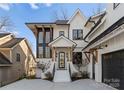 A beautiful two-story home featuring white brick, black trim, a modern front door, and well-manicured landscaping at 680 Ideal Way, Charlotte, NC 28203