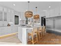 Bright kitchen featuring a marble waterfall island, stainless steel appliances, and stylish woven pendant lights at 680 Ideal Way, Charlotte, NC 28203