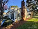 Exterior view highlighting the home's architecture, brick chimney, well-maintained landscaping, and inviting outdoor ambiance at 7327 Carrbridge Ln, Charlotte, NC 28226