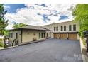 Spacious home with an expansive driveway and three-car garage, offering ample parking and outdoor space at 8014 Kiwi Pt, Tega Cay, SC 29708