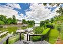 Breathtaking water view from a private dock, surrounded by lush greenery and a serene, cloud-filled sky at 8014 Kiwi Pt, Tega Cay, SC 29708