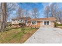 Lovely exterior showcasing a well-maintained lawn, a concrete driveway, and a classic brick and siding facade at 809 E 23Rd Street St, Newton, NC 28658