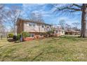 A sprawling exterior view of a tan and brick house showcasing its large yard and idyllic setting at 809 E 23Rd Street St, Newton, NC 28658