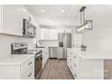 Modern white kitchen features stainless steel appliances, sleek countertops, and a stylish island with pendant lighting at 809 E 23Rd Street St, Newton, NC 28658