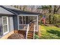 Home's inviting covered porch with classic rocking chairs and an American flag at 9401 Elvis Dr, Charlotte, NC 28215