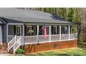 Charming home featuring a covered front porch with an American flag and rocking chairs at 9401 Elvis Dr, Charlotte, NC 28215