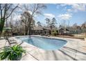 Backyard pool with lounge chairs, a barbecue grill, and mature trees for privacy at 9401 Elvis Dr, Charlotte, NC 28215