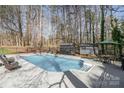 Backyard with a fenced in pool, patio, chairs, umbrella and storage sheds at 9401 Elvis Dr, Charlotte, NC 28215