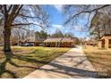 Traditional brick home with long driveway, showcasing a well-maintained lawn and established landscaping in a quiet setting at 11018 Despa Dr, Mint Hill, NC 28227
