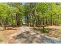 View down the long, tree-lined gravel driveway to the home at 123 Lucy Ln, Statesville, NC 28625
