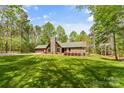 Charming stone and wood home with a stone chimney, green roof, and lush lawn at 123 Lucy Ln, Statesville, NC 28625