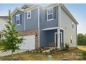 Two-story home with blue siding, brick accents, a two-car garage, and a covered front porch at 1305 31St Ne St, Conover, NC 28613
