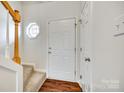 Bright entryway featuring hardwood floors, a staircase, and a decorative octagon window at 2035 Lennox Square Rd, Charlotte, NC 28210