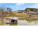 Waterfront home featuring a private dock on the lake and green lawn at 225 Kirkpatrick Rd, Taylorsville, NC 28681