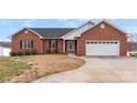 Charming brick home featuring an attached two car garage, a front yard, and lovely landscaping at 225 Kirkpatrick Rd, Taylorsville, NC 28681