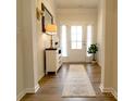 Bright entryway with wood floors, white trim, white front door and charming decor at 244 White Apple Way, Statesville, NC 28625