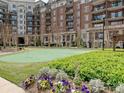 Putting green and landscaped gardens sit in front of an elegant brick apartment building at 300 W 5Th St # 402, Charlotte, NC 28202