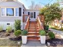Inviting front entrance with wooden stairs flanked by decorative planters, leading to a charming home at 3016 Hanson Dr, Charlotte, NC 28207