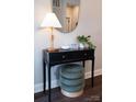 Stylish console table featuring a modern lamp, round mirror, decorative accents, and a comfortable green stool at 317 Old Town Village Rd, Waxhaw, NC 28173