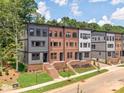 Charming townhome community featuring brick and neutral siding, well manicured lawns and blue skies at 317 Old Town Village Rd, Waxhaw, NC 28173