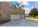 Spacious two-car garage with dormer windows and an extended driveway at 3907 Voltaire Dr, Monroe, NC 28110