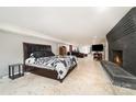 Spacious basement bedroom with brick fireplace, painted concrete floors, and neutral walls at 401 Dakota St, Kannapolis, NC 28083